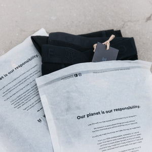 Image of two packages from Woolf Merino with a piece of black clothing sticking out.