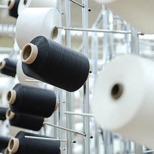 Image of black and white spools of thread on metal racks