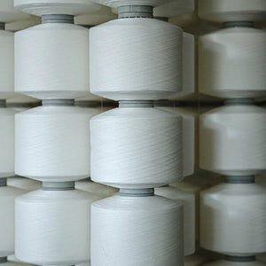 Closeup photo of white thread on spools