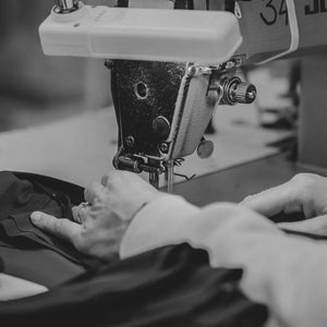 Black and white image of a woman's hands using a sewing machine