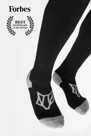 Image of a person's legs against a white background wearing Ulsaak Tech Socks and the Forbes magazine logo with text saying "Best Snowboard & Ski Socks"